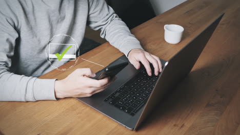 male person on laptop pays for online purchase with stored credit card smartphone app