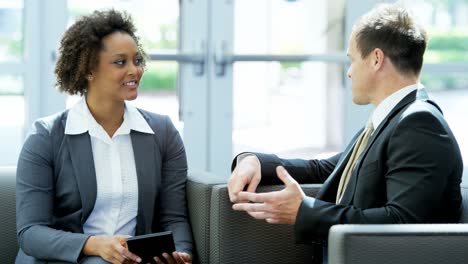 asesor de negocios afroamericano caucásico que usa una tableta inalámbrica