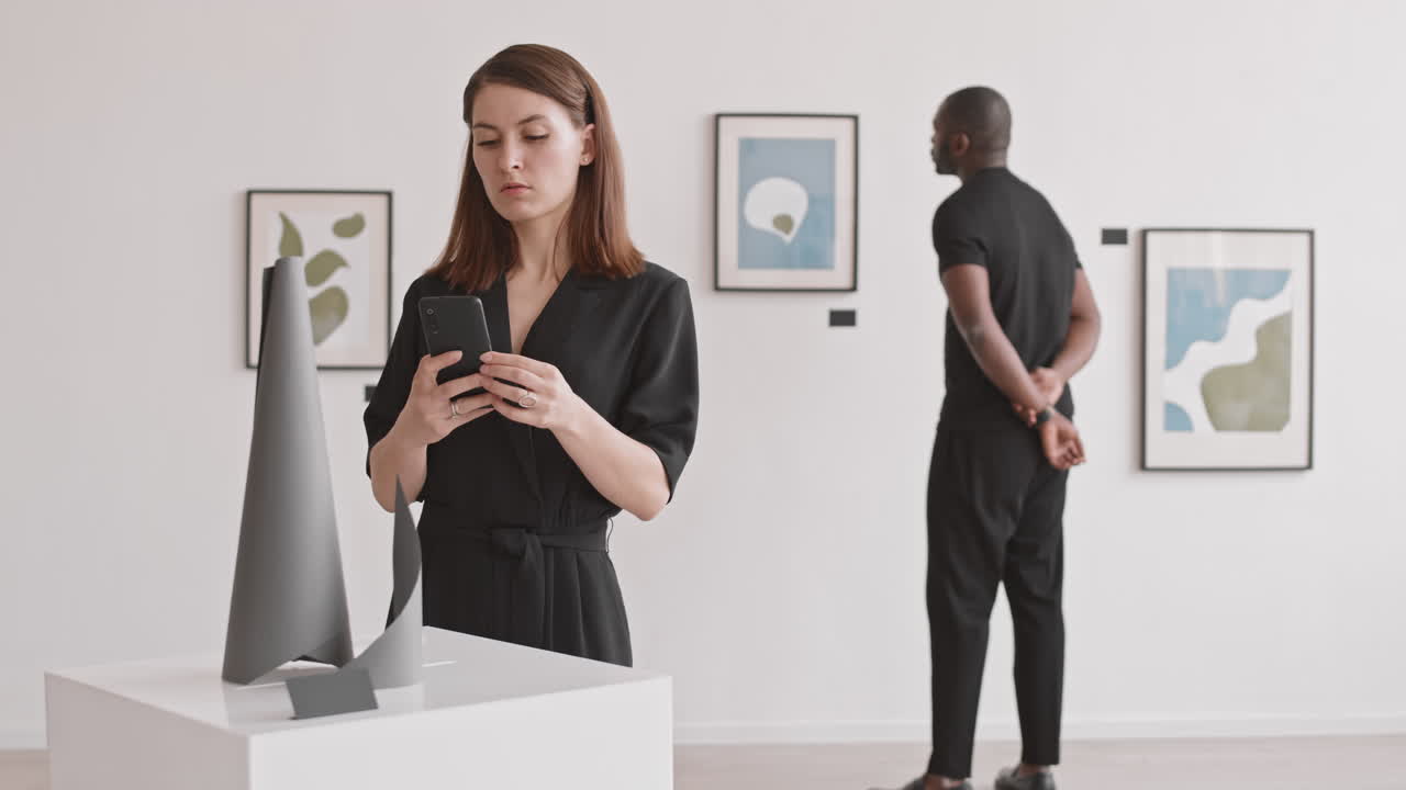 Woman Photographing Art Object in Gallery