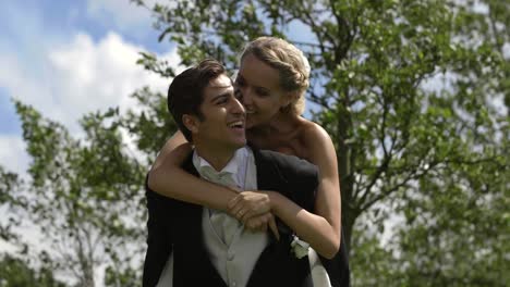 groom giving his pretty wife a piggy back