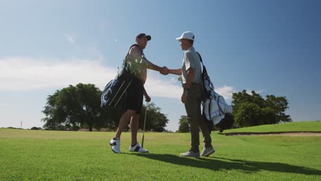 caucasian male golfers standing on a golf course on a sunny day