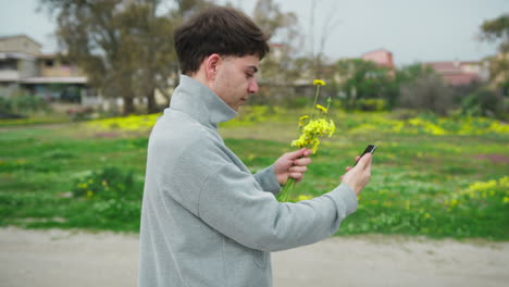 man showing flowers to his loved one while having a videocall outdoor