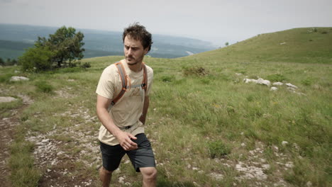 hiker walking up a hill towards the top of mountain slavnik, with the view at the adriatic sea in background