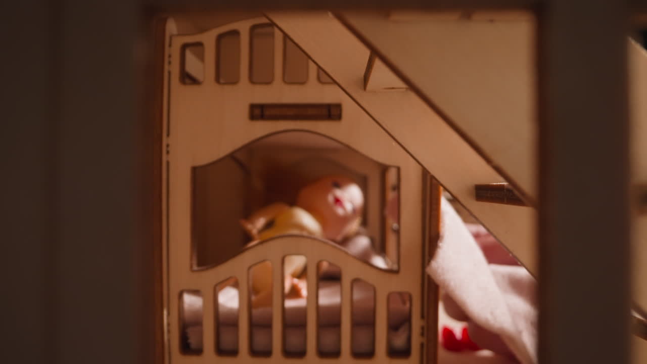 작은 아이는 침대에 누워있는 돌리를  ⁇ 기 위해 천을 들고 있습니다.