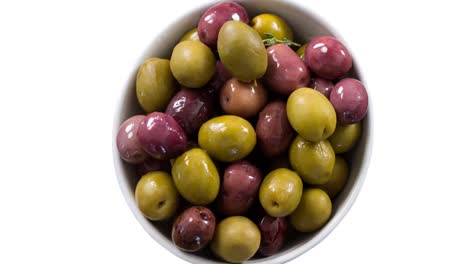 Animation-of-olives-in-bowl-over-white-background