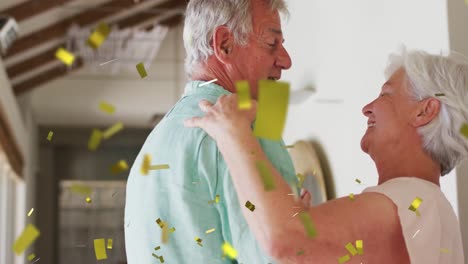 animation of gold confetti falling over happy caucasian senior couple dancing at home