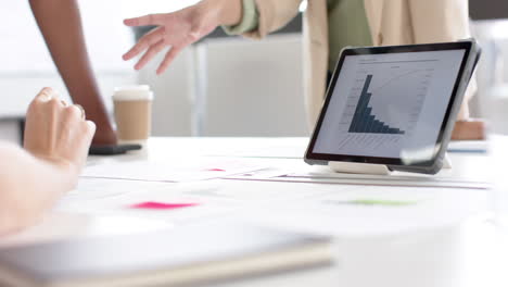 Hands-of-diverse-creative-female-colleagues-in-meeting-in-board-room-with-tablet,-slow-motion