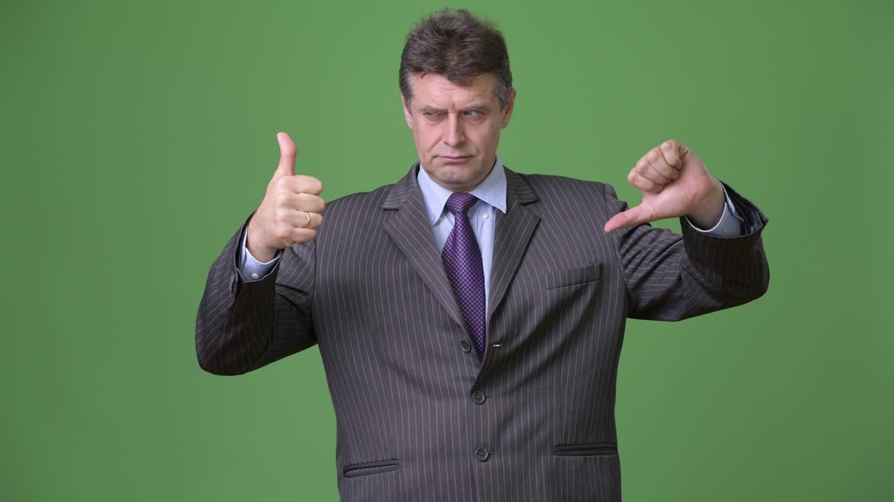 Yeşil arka planda olgun, yakışıklı iş adamı.