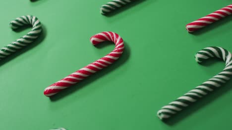 red and green striped candy canes on green background