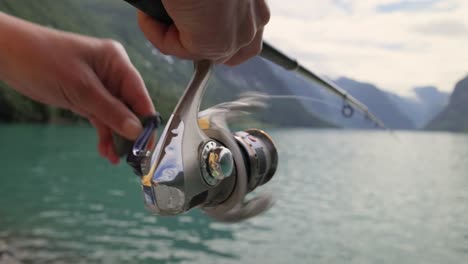 mujer pescando en una caña de pescar girando en noruega.