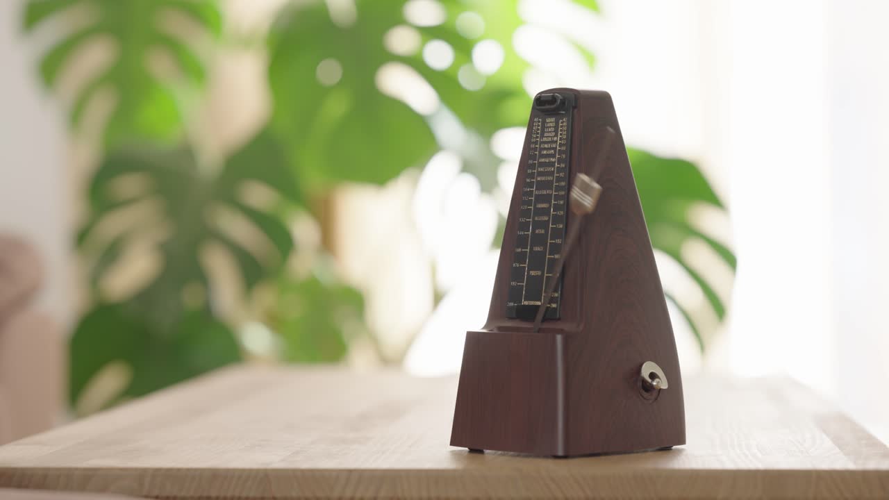 Vintage metronome ticking steadily on wooden table