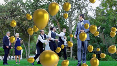 golden balloons animation over people celebrating outdoors in formal attire