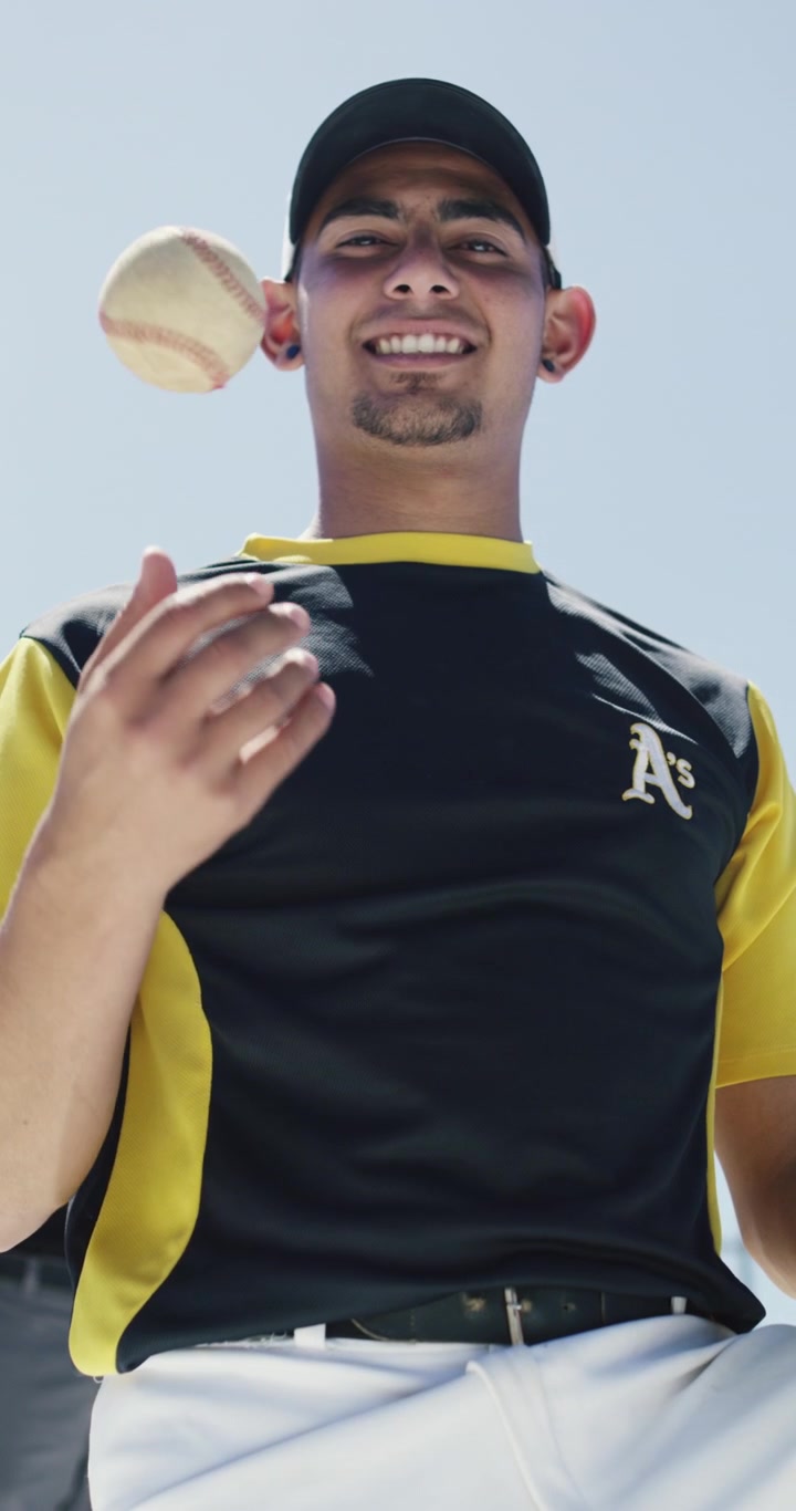 Giovane giocatore di baseball che lancia una palla in aria
