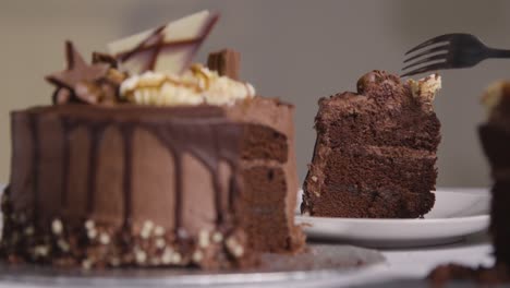 Primer-Plano-De-Una-Persona-En-Casa-Comiendo-Un-Trozo-De-Pastel-De-Celebración-De-Chocolate-Del-Plato-En-La-Mesa