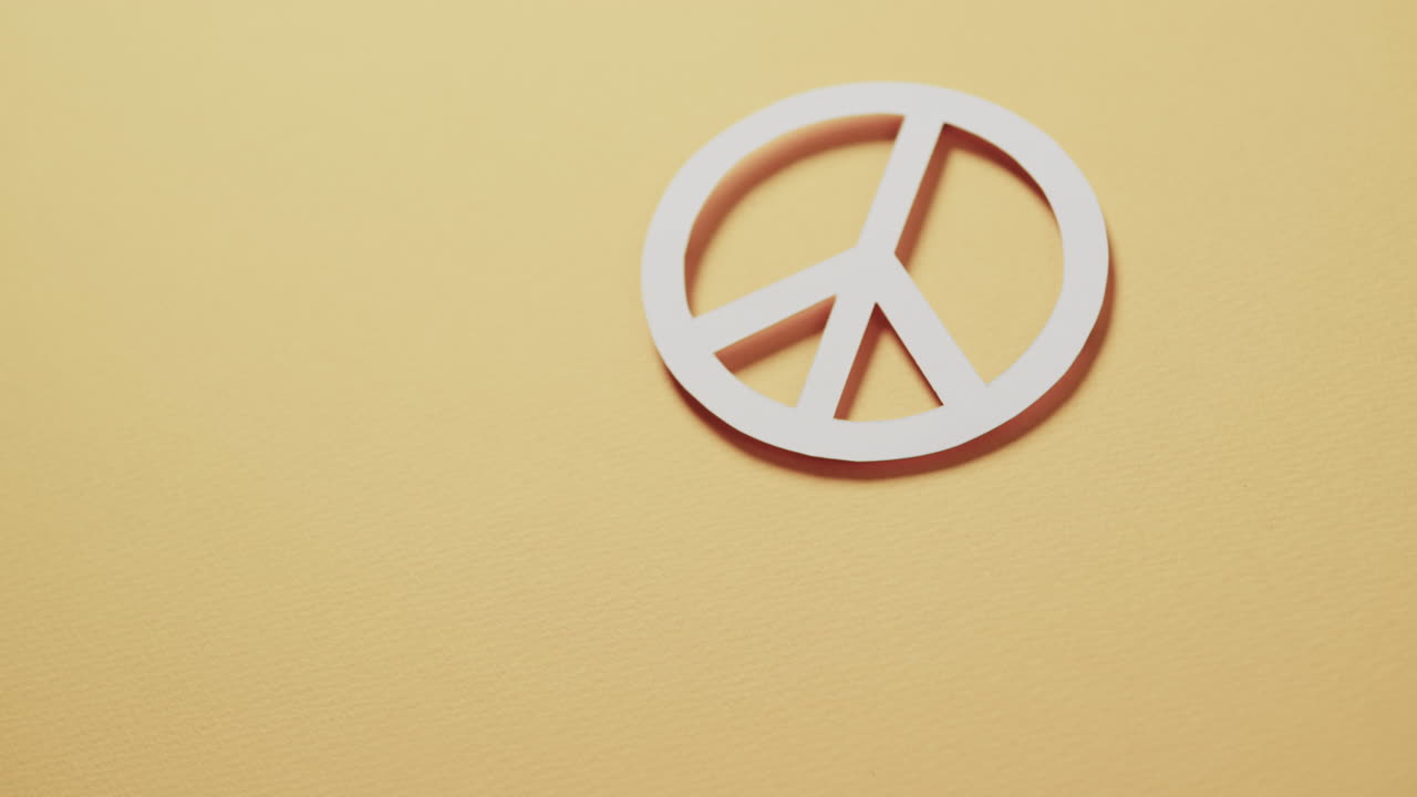 노란색 배경에 있는 색 평화 표지판과 복사 공간의 클로즈업