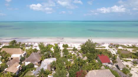 Weitwinkel-Drohne-Schwenkt-Nach-Oben,-Um-Die-Wunderschönen-Weißen-Sandstrände-Der-Tropischen-Insel-Holbox-In-Mexiko-An-Einem-Sonnigen,-Heißen-Tag-Mit-Resorts-Und-Hotels-In-Der-Ferne-In-4k-Zu-Enthüllen