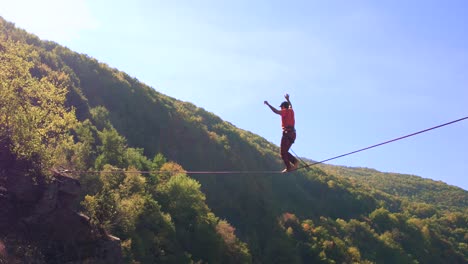 man slacklining across a mountain cliff