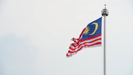 waving malaysian flag against the sky