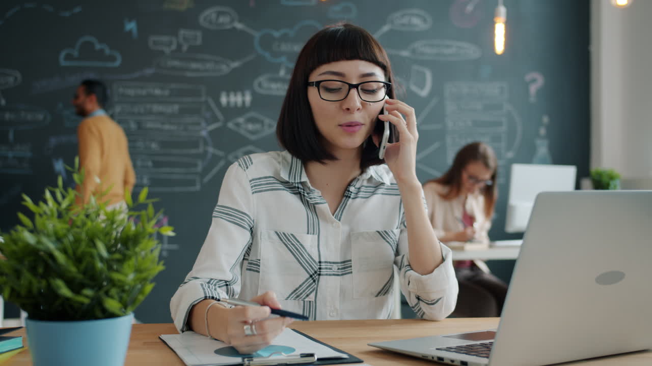 Žena telefonující v moderní kanceláři