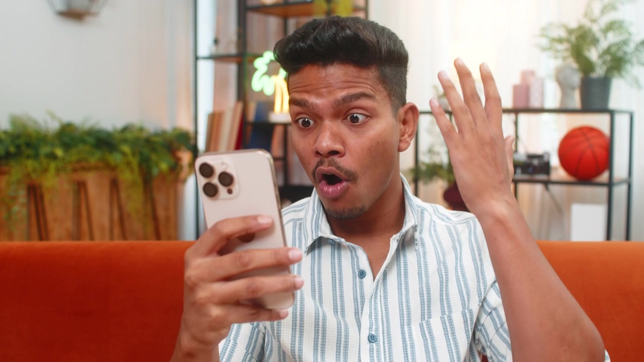 Indian man scrolls smartphone feed sees big discounts says wow smiles at online shop offers news hot