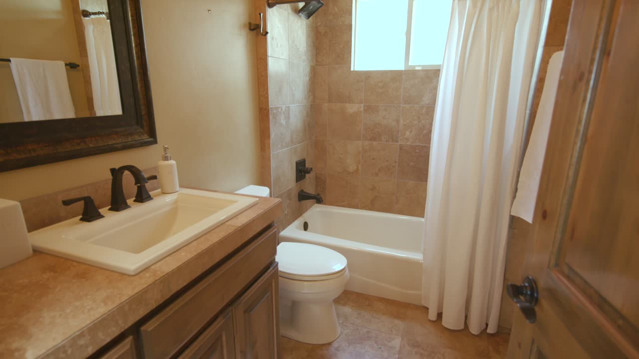 Tan Bathroom Rise from Doorway to Shower