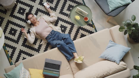 Woman-Lying-on-Floor-and-Listening-to-Music-with-Headphones