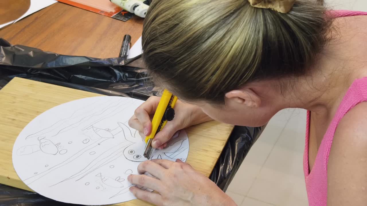 Woman Cutting an Underwater Scene from Paper