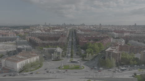 Aerial-drone-shot-of-the-spectacular-cityscape-and-skyline-of-Madrid,-tracking-backwards-revealing-the-Puente-de-Toledo-bridge,-Madrid-Río-park-and-Manzanares-river-below-in-Arganzuela,-Spain