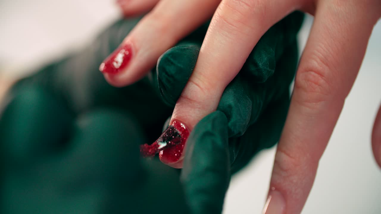 미용사는 미용실에 있는 여성의 손톱에 매니큐어를 바르다