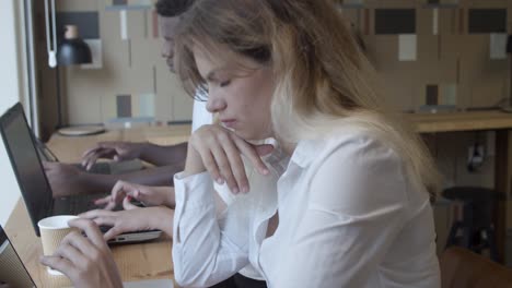 row of serious freelance workers sitting at counter