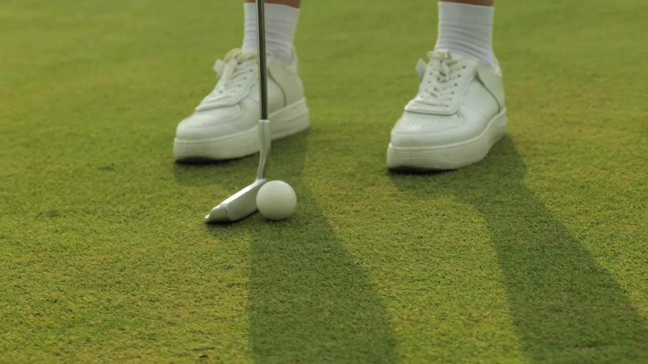 Close-up of a Golfer Putting a Golf Ball on the Green