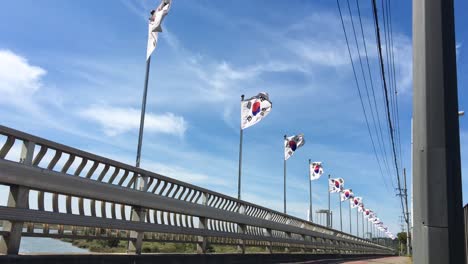 a bridge with flags flying in ansan, sangnok, gyeonggi-do, south korea