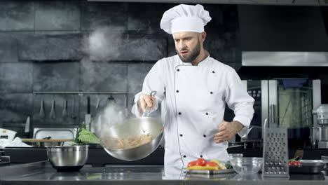 chef cocinando comida en la sartén en la cocina