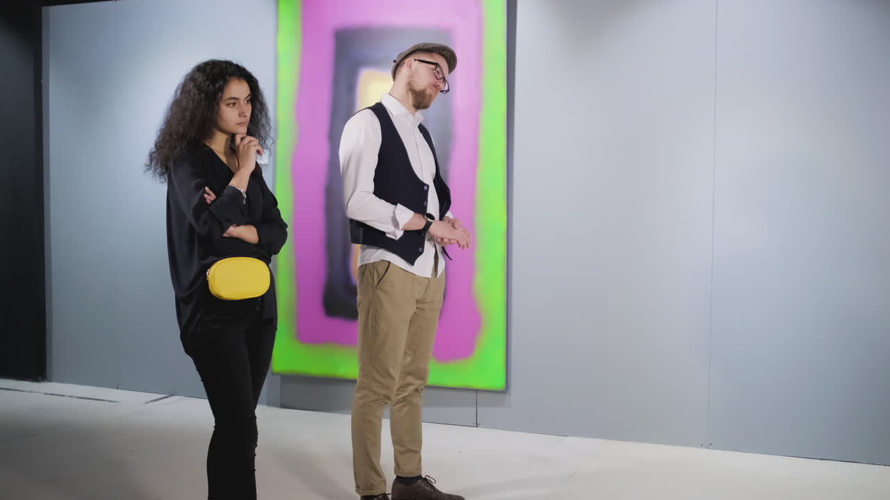 pareja viendo arte abstracto en una galería de arte