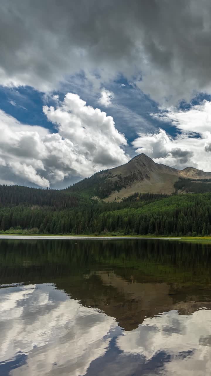 Vertical 3k Timelapse of Clouds Reflection on Alpine Lake and Mountain Peak in Summer Season