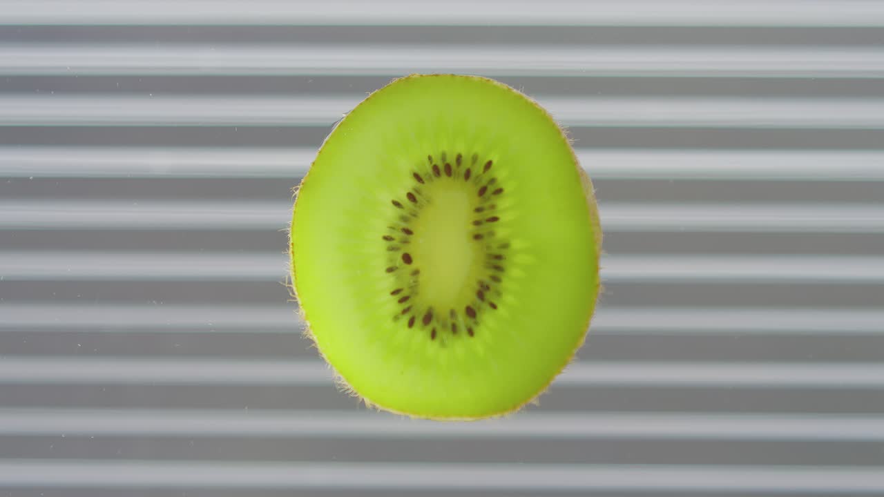 um pedaço de kiwi gotas de fruta e salpicos
