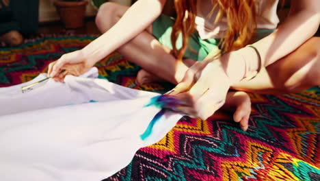 young woman creating a tie-dye design on a t-shirt