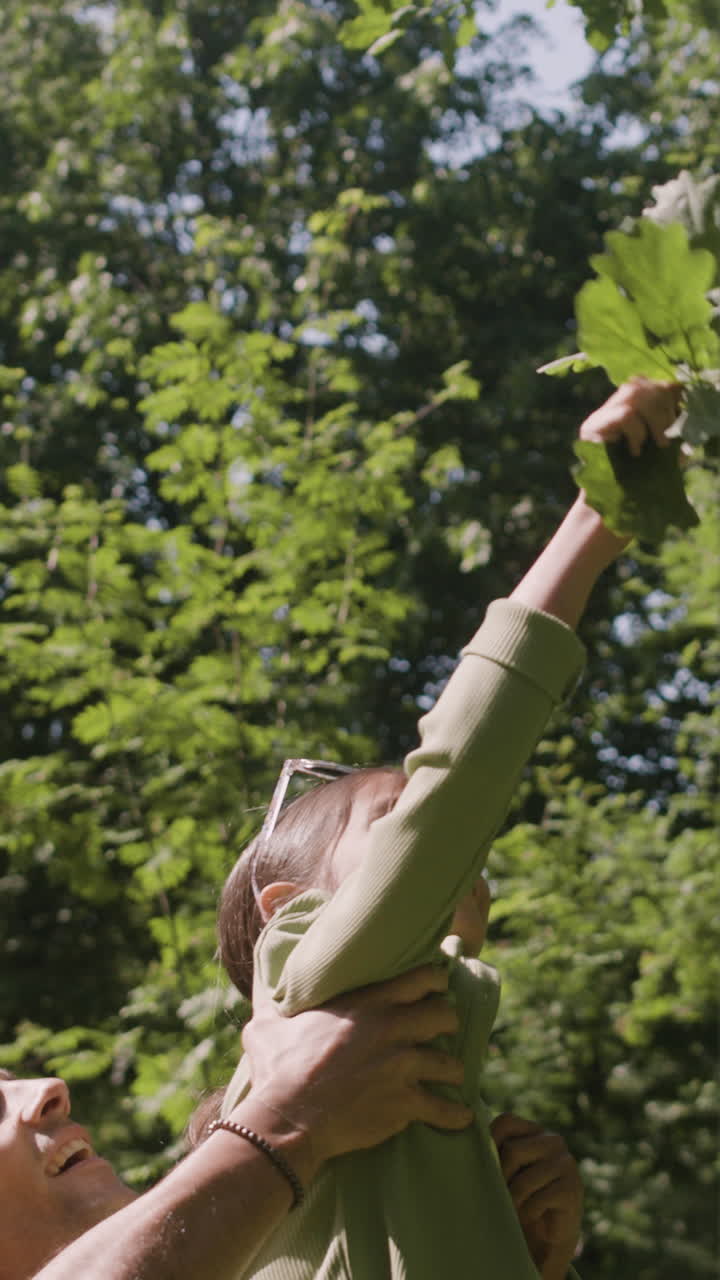 Father and daughter collecting leaves in the park