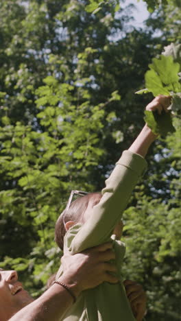 father and daughter collecting leaves in the park