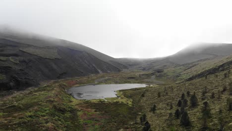 pequeña laguna de cráter volcánico en la isla de são miguel, azores, portugal - sobrevuelo aéreo empuje en tiro revelador