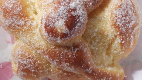 panning closeup of golden baked bread of the dead, pan de muerto,bun. traditional sweet bread from mexico on dia de los muertos, all saints day.