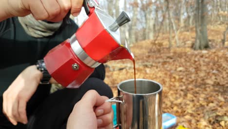 Nahaufnahme-Eines-Mannes,-Der-Auf-Einem-Campingplatz-Im-Wald-Kaffee-In-Eine-Tasse-Gießt