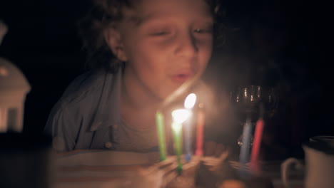 boy blowing out his birthday candles