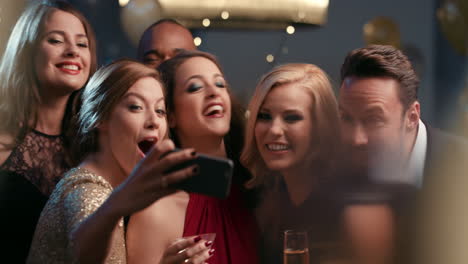 un grupo de amigos sonrientes celebran un evento nocturno con una selfie en una fiesta