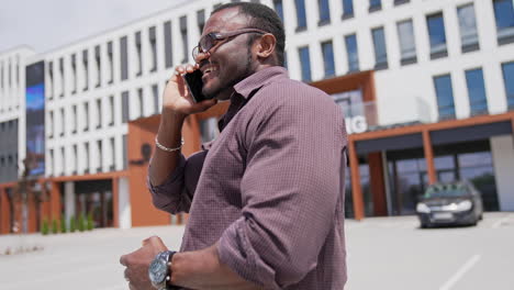 african man using phone. black man talking on the phone in the street
