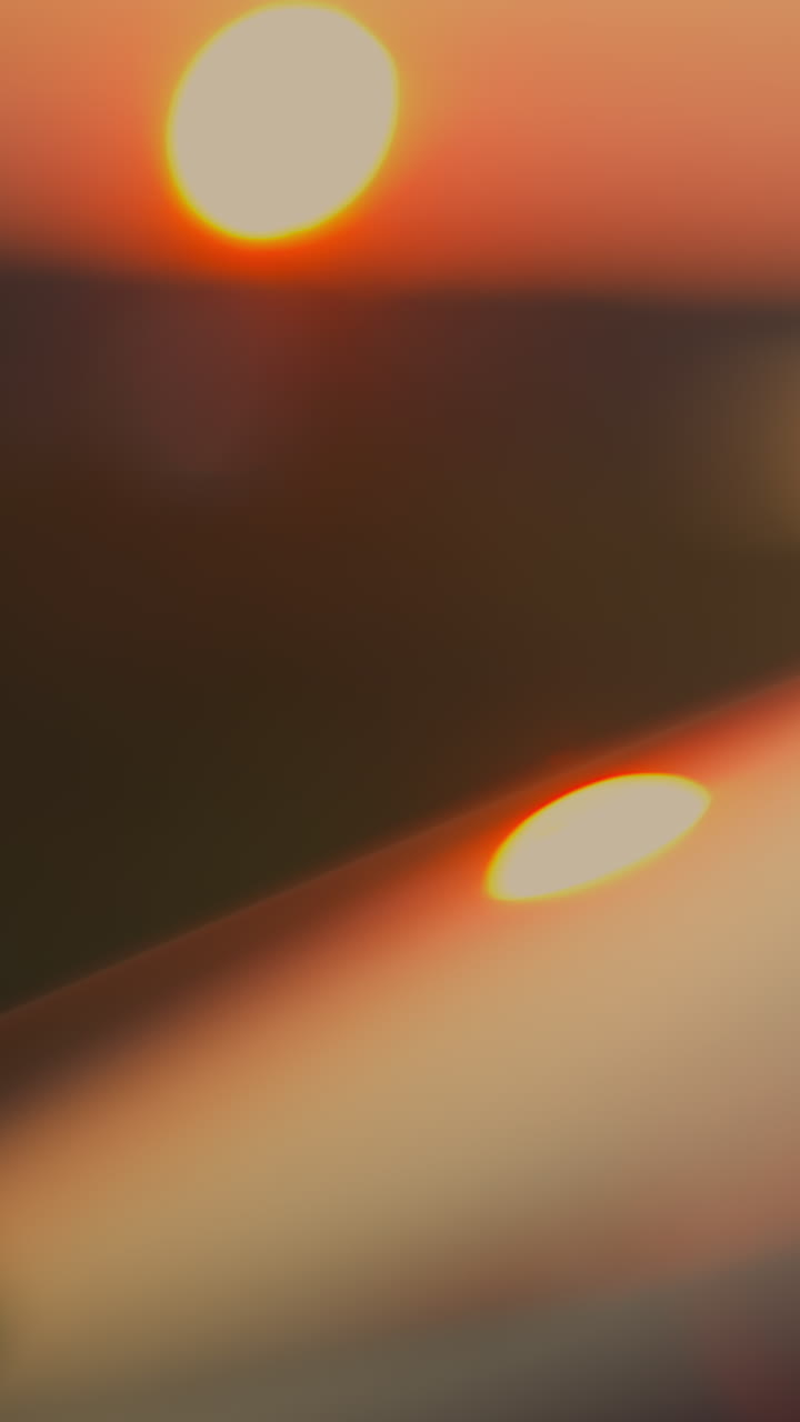 parabrisas del coche iluminado por la luz del atardecer de primer plano. superficie de espejo de la ventana de automóvil moderno en el sol del crepúsculo rojo en la calle. conducir un vehículo en la noche dramática