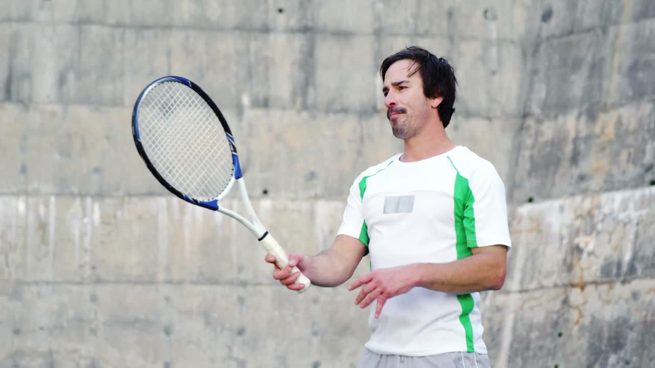 라켓 을 들고 서 있는 피곤 한 운동 선수