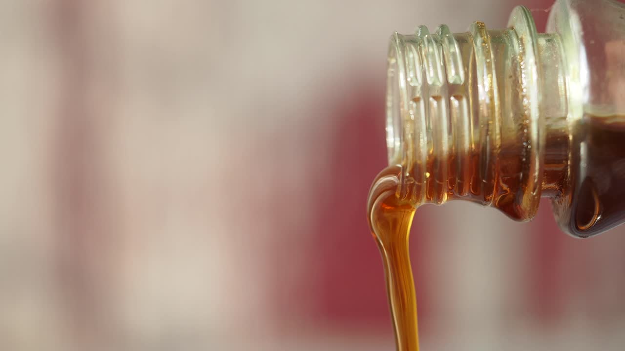 Liquido ambrato che si versa da una bottiglia