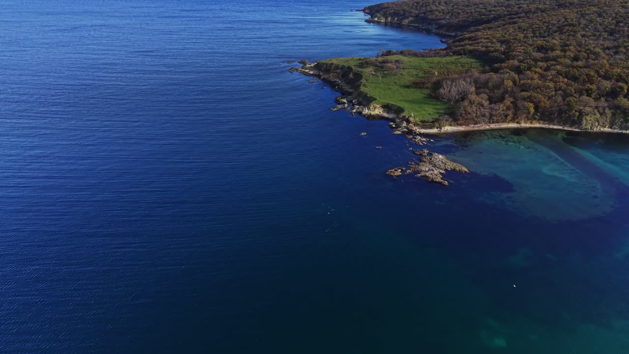 Beautiful coastal view with lush greenery and clear blue waters at sunset