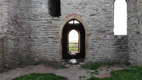 Backwards-reveal-shot-of-a-doorway-of-Church-Ruins-at-Burrow-Mump-England